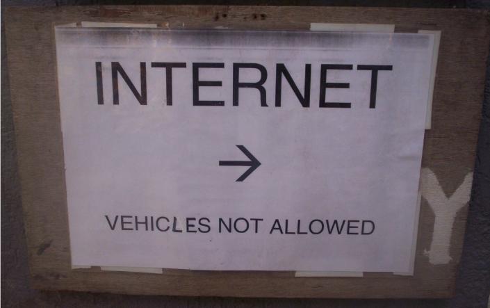 A notice board reading 'INTERNET →' and 'VEHICLES NOT ALLOWED', photographed in India circa 2008